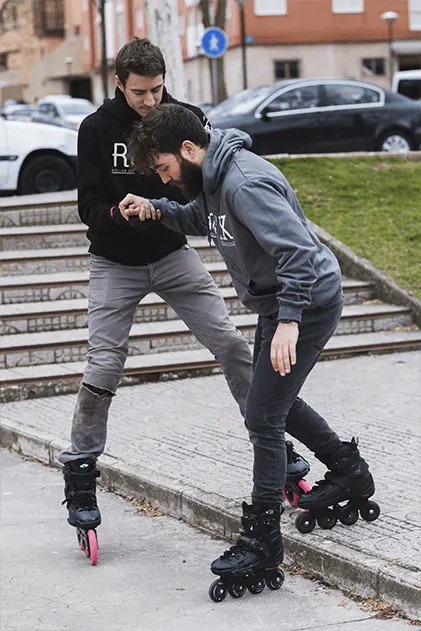 Aprender a patinar - Chico ayudando a otro a bajar un escalón